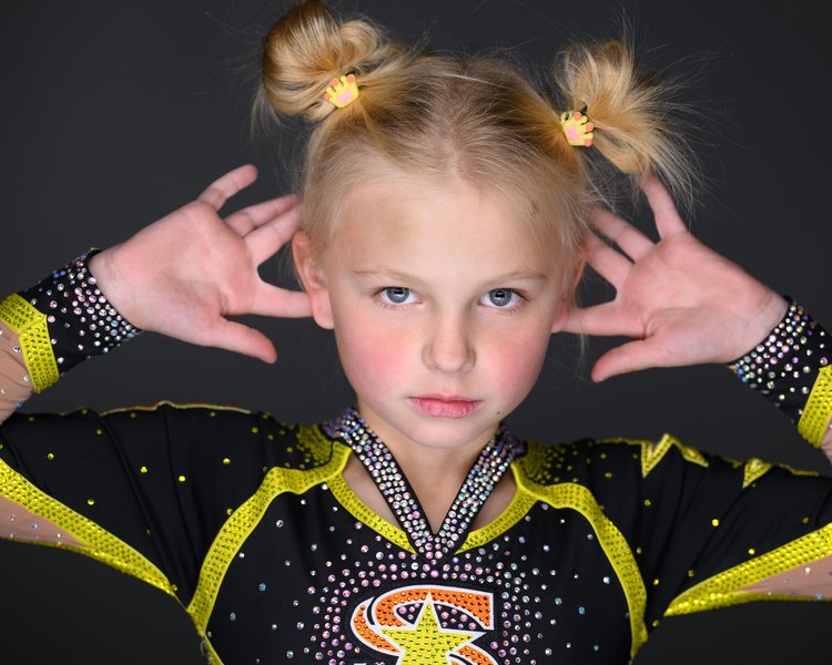 Young competitive cheer athlete striking a fierce pose in uniform