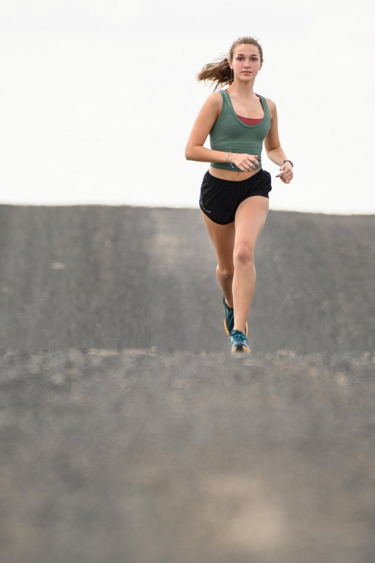 Track athlete running outdoors during an action photography session